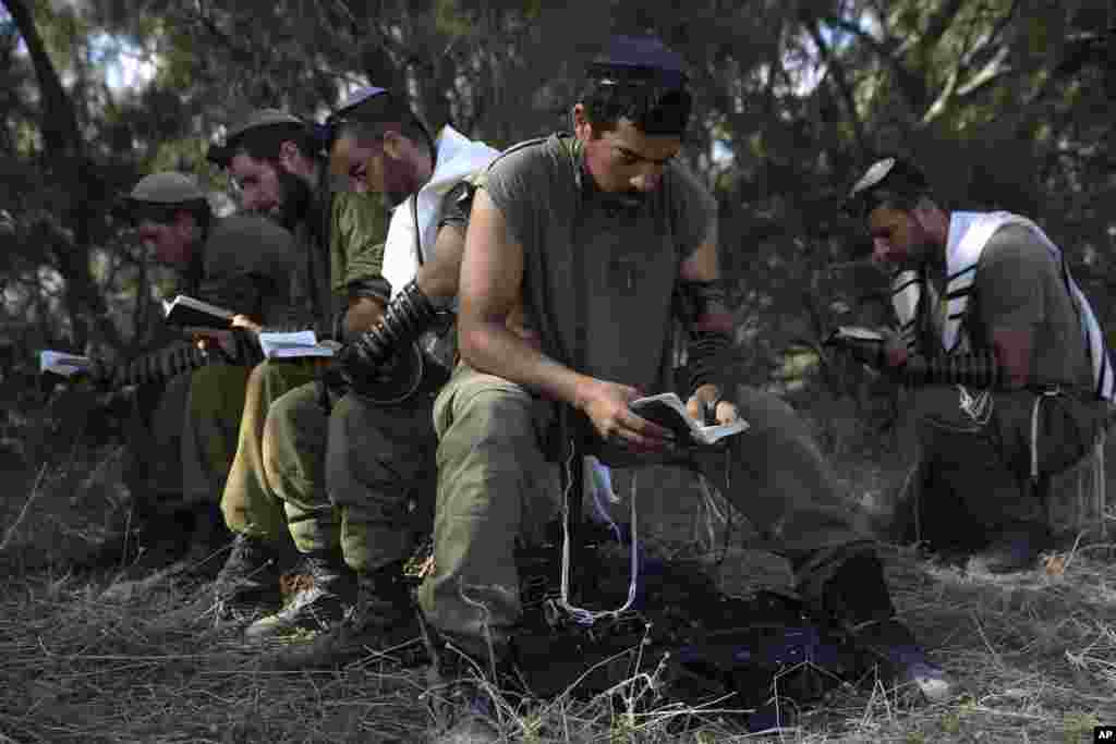 Israeli reserve soldiers pray after returning to Israel from the Gaza Strip near the Israel-Gaza border, Aug. 4, 2014.