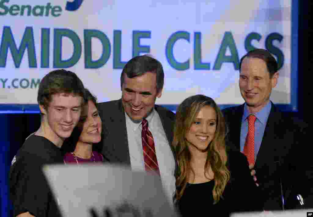 Sen. Jeff Merkley, D-Ore., center, with from left, son Jonathan Merkely, wife Mary and daughter Brynne Merkely and Sen Ron Wyden, D-Ore., greets supporters at the Democratic election night party in Portland Ore., Nov., 4, 2014. 