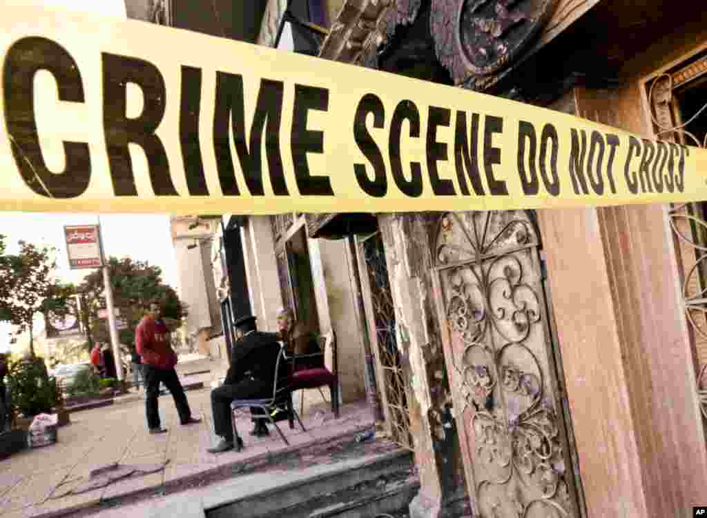 Egyptian policemen guard the scene of the El Sayad restaurant which was attacked in Cairo. More than a dozen were killed and wounded in the fire-bombing. Reports said three men on a motorcycle threw Molotov cocktails into the club in the Agouza district and then fled.
