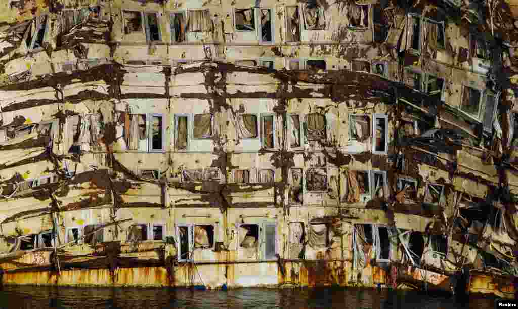 The side of the cruise liner Costa Concordia is seen during the "parbuckling" operation outside Giglio harbor. Thirty massive tanks filled with air will lift the hulk of the Costa Concordia off the seabed in June so that it can be towed away from the Italian island where it capsized two years ago, officials said. The 114,500-tonne vessel hit rocks on Jan. 13, 2012, killing 32 people.