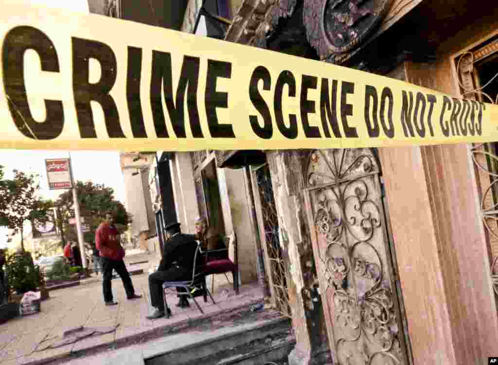 Egyptian policemen guard the scene of the El Sayad restaurant which was attacked in Cairo. More than a dozen were killed and wounded in the fire-bombing.&nbsp; Reports said three men on a motorcycle threw Molotov cocktails into the club in the Agouza district and then fled.