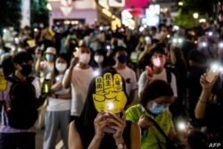La gente sostiene sus teléfonos con la luz encendida en Hong Kong, el 4 de junio de 2021, después de que la policía cerró el lugar donde la gente de Hong Kong se reúne anualmente para llorar a las víctimas de la represión de la plaza de Tiananmen.