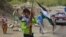 Des enfants portant des fusils de chasse et un drapeau traversent une route dans la région de Bandejoy du district de Dara, dans la province du Panjshir, le 21 août 2021, quelques jours après la prise de contrôle de l'Afghanistan