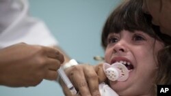 Seorang anak sedang divaksinasi campak di Rio de Janeiro, Brazil, 6 Agustus 2018.