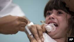 Seorang anak menerima vaksinasi campak di Rio de Janeiro, Brazil. 