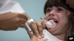 FILE - A child receives a measles vaccination in Rio de Janeiro, Brazil, Aug. 6, 2018.