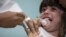 FILE - A child receives a measles vaccination in Rio de Janeiro, Brazil, Aug. 6, 2018.