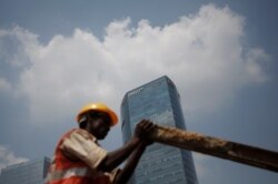 A laborer works at a construction site next to American Express office in Gurugram on the outskirts of New Delhi, India, Sept. 8, 2017.