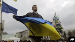 Un manifestante ondea la enseña nacional de Ucrania en la Plaza de la Independencia, en Kiev.