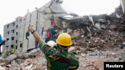 A rescue worker attempts to find survivors from the rubble of the collapsed Rana Plaza building in Savar, 30 km (19 miles) outside Dhaka, April 30, 2013. 