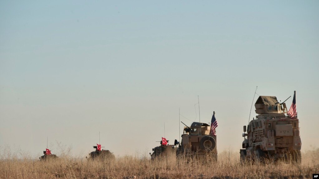 In this photo taken Nov. 1, 2018, Turkish and U.S. troops conduct joint patrols around the Syrian town of Manbij, as part of an agreement that aimed to ease tensions between the two NATO allies
