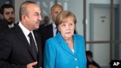Turkish Foreign Minister Mevlut Cavusoglu talks with German Chancellor Angela Merkel in Duesseldorf, western Germany, May 29, 2018. 