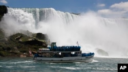 FILE - Tourists ride the Maid of the Mist tour boat at the base of the American Falls in Niagara Falls, New York, June 11, 2010.