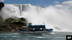FILE - Tourists ride the Maid of the Mist tour boat at the base of the American Falls in Niagara Falls, New York, June 11, 2010.