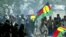 FILE - Pro-independance demonstrators hold a Kanak flags as they face French riot police during a protest outside the New Caledonian northern province assembly while [French President Jacques Chirac] was paying a visit to the New Caledonian northern city 