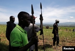 Members of the Luo ethnic group hold spears near the town of Muhoroni in Kisumu County, Kenya, Oct. 29, 2017. Luo residents have been blocking roads as part of a political protest. They says they were prevented from getting to polling stations to vote Thursday.