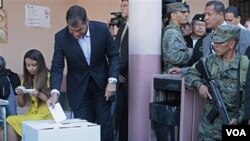 Presiden Ekuador Rafael Correa (tengah) memberikan suaranya dalam referendum di Quito, Sabtu (7/5).