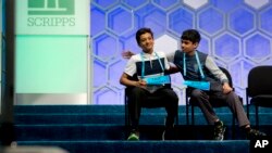 Jairam Hathwar, 13, of Painted Post, N.Y., left, and Nihar Janga, 11, of Austin, Texas, right, pat each other on the back as they hear that they will likely be announced co-champions after a drawn-out battle that did indeed end in them being named co-cham