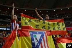 Atletico Madrid supporters hold up a Spanish flag reading: "Catalonia is Spain" during a Spanish La Liga soccer match between Atletico Madrid and Barcelona at the Metropolitano stadium in Madrid, Spain, Oct. 14, 2017.