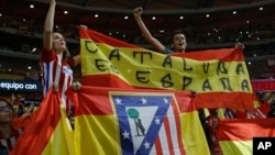 Atletico Madrid supporters hold up a Spanish flag reading: "Catalonia is Spain" during a Spanish La Liga soccer match between Atletico Madrid and Barcelona at the Metropolitano stadium in Madrid, Spain, Oct. 14, 2017. 