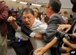 FILE - Pro-democracy lawmaker Wu Chi-wai, center, scuffles with information    guards astatine  the Legislative Council successful  Hong Kong, May 11, 2019.