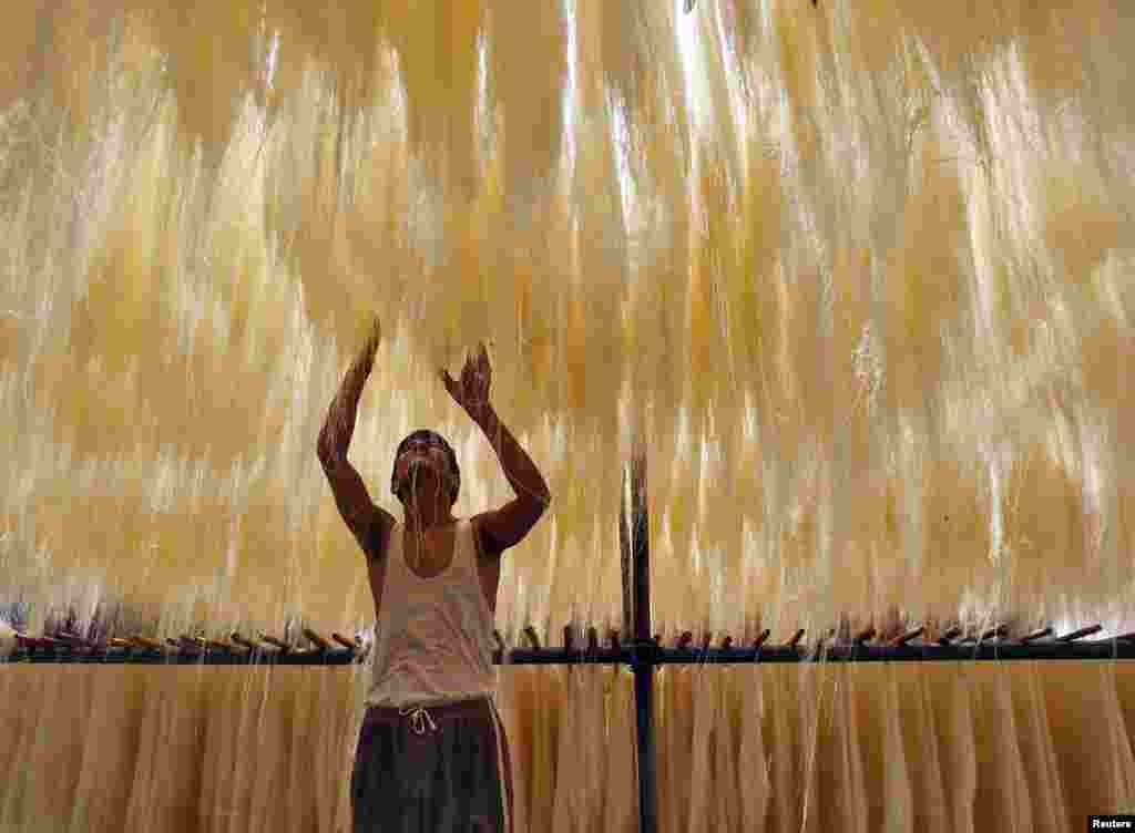 A man arranges strands of vermicelli,&nbsp;a specialty that is eaten during the Muslim holy month of Ramadan, as they dry in a factory, in the northern city of Allahabad, India, July 1, 2014.