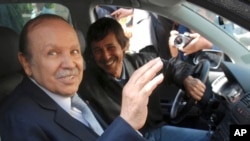 FILE - Algerian President Abdelaziz Bouteflika, left, and his brother Said Bouteflika arrive at campaign headquarters in the Hydra district of Algiers, April 10, 2009.