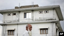 A resident walks on May 5, 2011 past the compound in Abbottabad, Pakistan, where US Navy SEALs killed Osama bin Laden