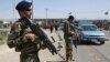 In this July 10, 2018 photo, an Afghan national army soldier stops a car at a temporary checkpoint on the outskirts of Kabul, Afghanistan.