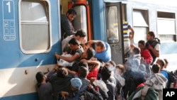 Migrantes luchan por abordar un tren en la estación de Keleti en Budapest.