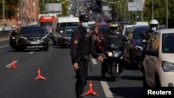 Policajac sa zaštitnom maskom reguliše saobraćaj u Madridu
