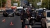 A police officer wearing a protective mask stands at a traffic checkpoint during a partial lockdown amid the coronavirus pandemic, in Madrid, Spain Oct. 9, 2020.