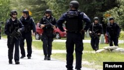 Law enforcement officials search a street near the Clinton Correctional Facility in Dannemora, New York, from which two convicts broke out about a week ago, June 10, 2015. 