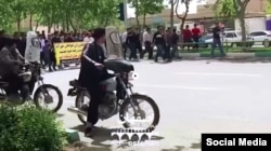 FILE - In this frame from a social media video posted April 13, 2018, people in Khorasgan, Iran, march to protest water shortages that are hurting local farmers.