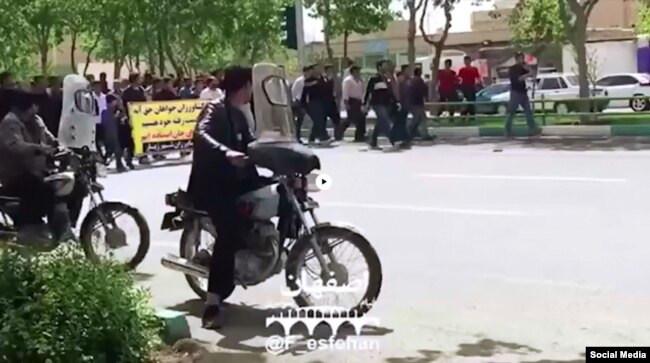 FILE - In this frame from a social media video posted April 13, 2018, people in Khorasgan, Iran, march to protest water shortages that are hurting local farmers.