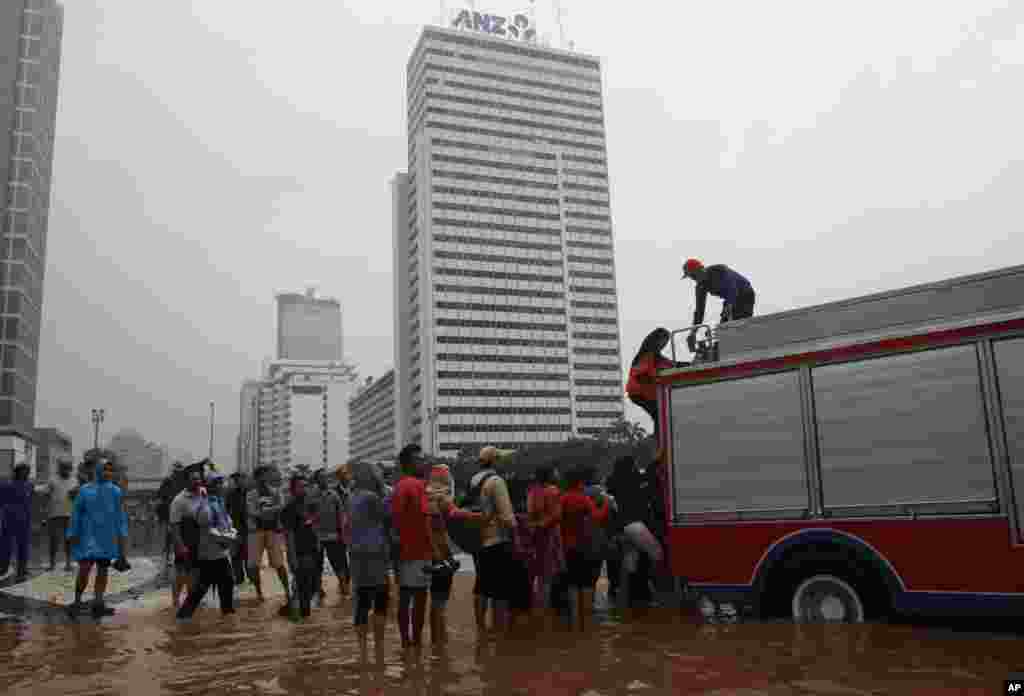 Indonesian firefighters help people in a flooded street in Jakarta, Indonesia, January 17, 2013.