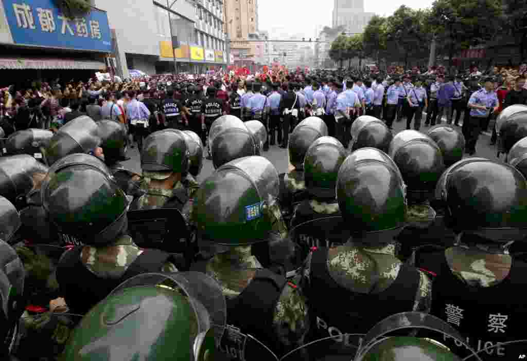 Demonstrators are surrounded by uniformed policemen and paramilitary policemen during a protest against Japan in Chengdu, in southwest China's Sichuan province, September 18, 2012. 