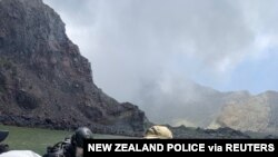 Members of a dive squad conduct a search during a recovery operation around White Island, a volcanic island that erupted earlier this week, in New Zealand, Dec. 13, 2019, in this police handout photo.