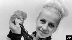 FILE - In this Oct., 1968, file photo, Vera Caslavska of Czechoslovakia holds her four Olympic medals, three gold and one silver which she won in the gymnastics competition. 