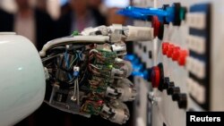 FILE - The hand of humanoid robot AILA (artificial intelligence lightweight android) operates a switchboard during a demonstration at the CeBit computer fair in Hanover, March, 5, 2013.