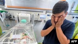 Ayman Abu Shamalah stoji pored svoje kćerke Meke, dok je zbrinuta u inkubatoru u bolnici u Rafi 23. oktobra 2023.
