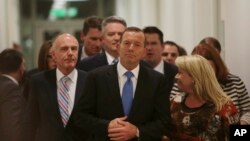 Australian Prime Minister Tony Abbott, center, leaves the Australian Liberal Party meeting in which he lost the party leadership at Parliament House in Canberra, Monday, Sept. 14, 2015.