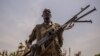FILE- A rebel soldier poses with his gun in Touch Riak, Leer county, on March 7, 2018, where famine has been declared since February 2017. The ICRC left the area after gunmen fired on the organization's compound.