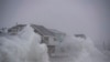 File - Waves crash over oceanfront homes during a nor'easter in Scituate, Massachusetts on January 29, 2022. 