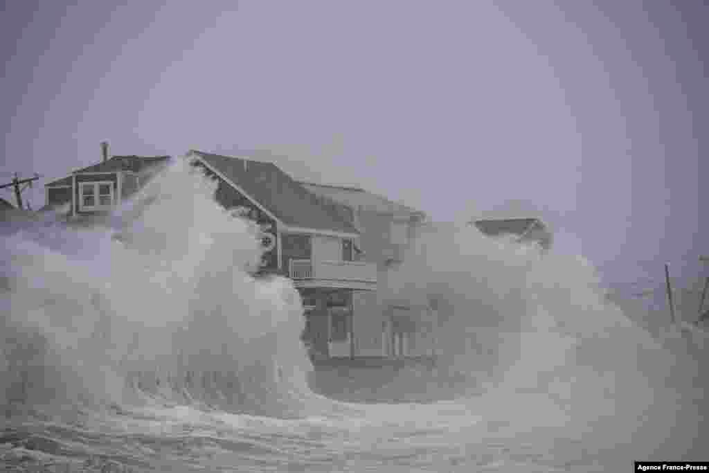 Waves crash over oceanfront homes during a nor&rsquo;easter in Scituate, Massachusetts, Jan. 29, 2022.