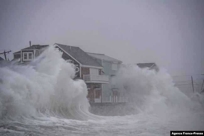 Ombak menghantam rumah-rumah di tepi pantai di Scituate, Massachusetts, 29 Januari 2022. (JOSEPH PREZIOSO / AFP)