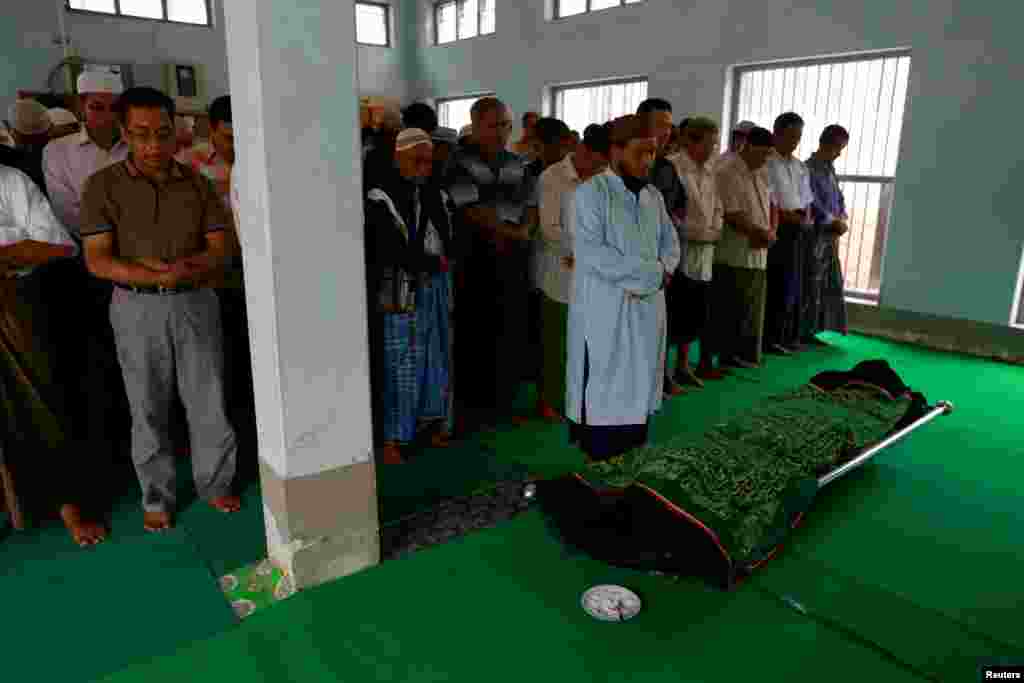 Muslims pray near the body of Soe Min, a 51-year-old man who was killed in a recent riot, at a mosque in Mandalay, Myanmar, July 3, 2014. 