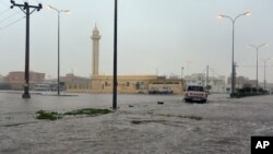 FILE - In this Nov. 24, 2015 image released by the Saudi Press Agency, SPA, a car drives on a flooded street in Al-Qassim Region, west of Riyadh, Saudi Arabia.