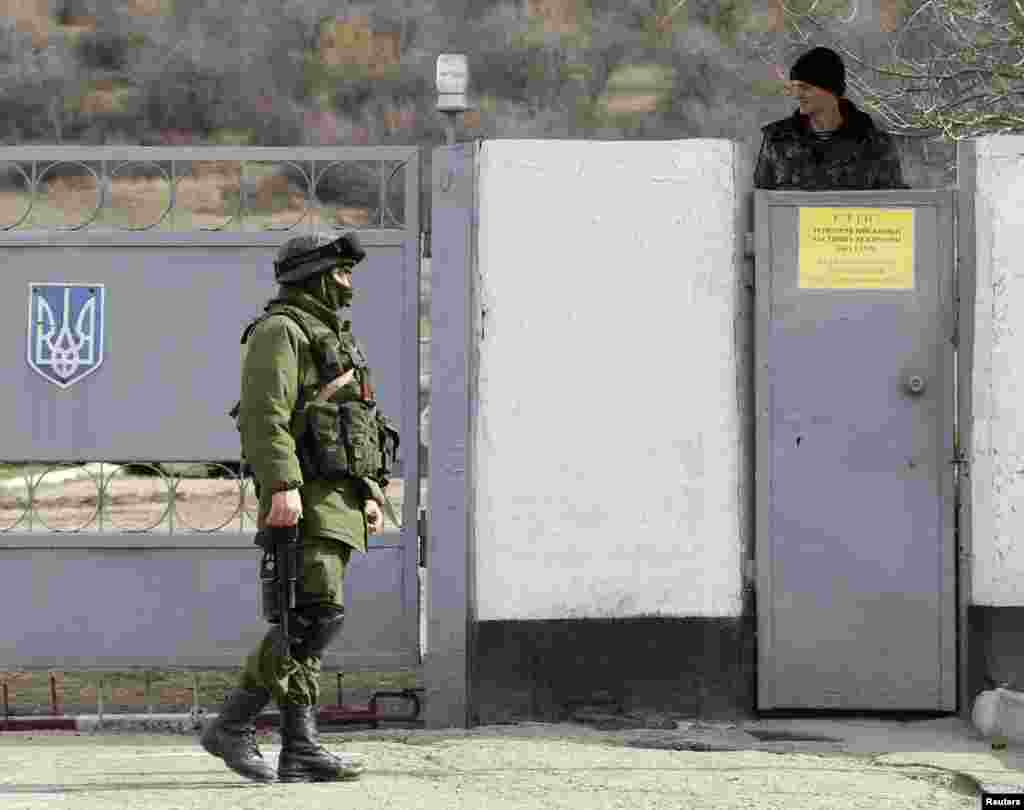 Ruski vojnik u ukrajinskoj uniformi na straži u vojnoj bazi blizu krimskog sela Perevalnoja, kod Simferopola, 6. mart, 2014. 