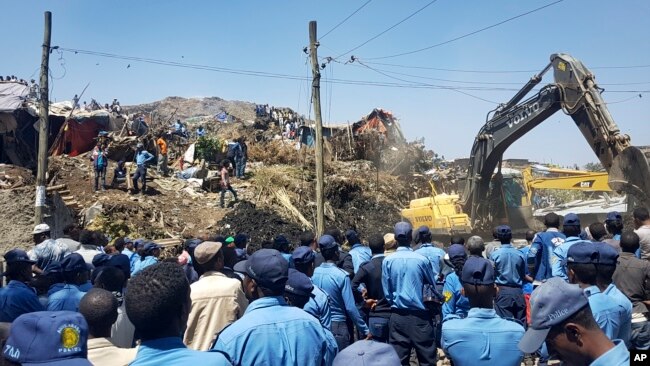 Police officers secure the perimeter at the scene of a garbage landslide, as excavators aid rescue efforts, on the outskirts of the capital Addis Ababa, Ethiopia, March 12, 2017. 